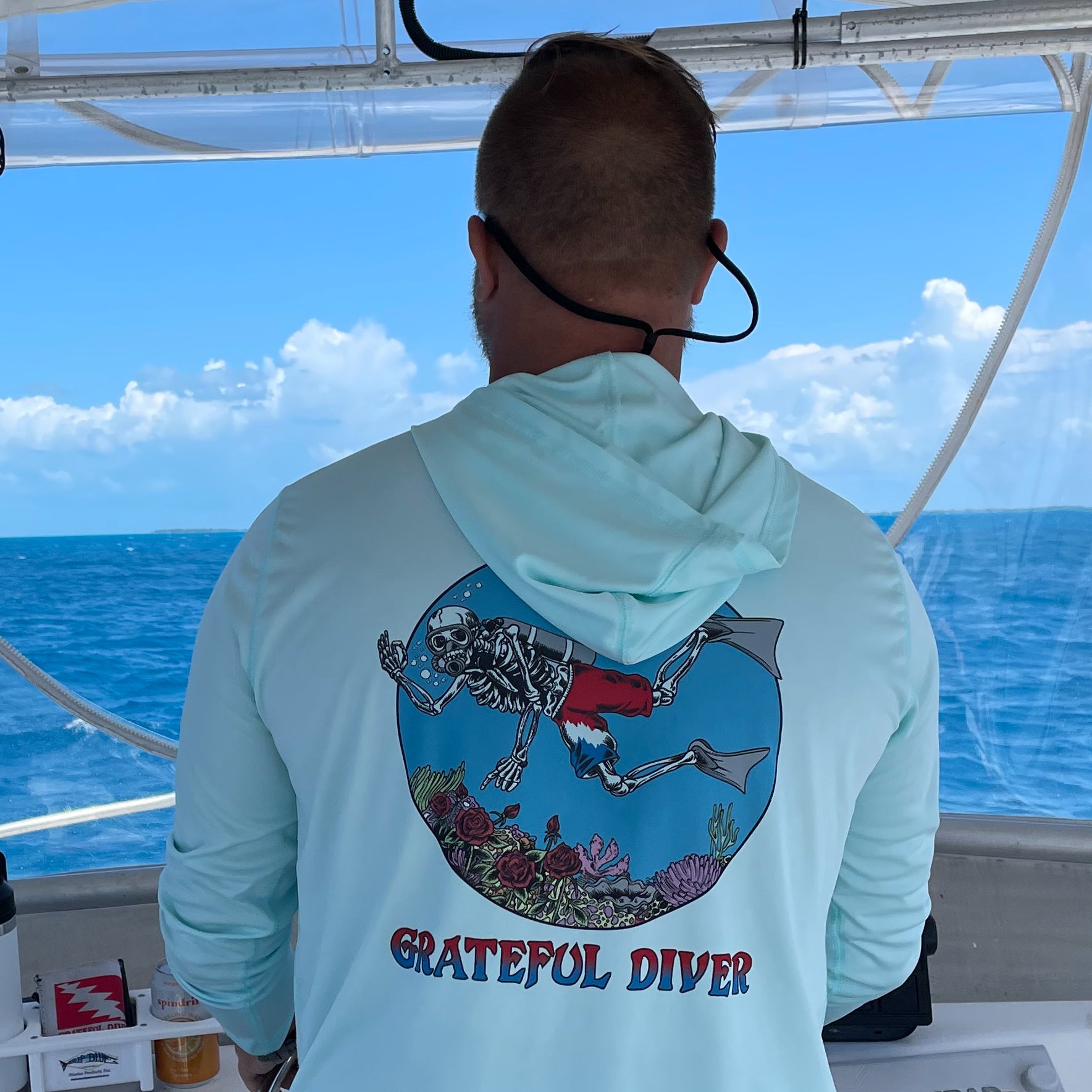 Grateful Diver Skeleton Diver UV Hoodie in seagrass on model showing back on a boat