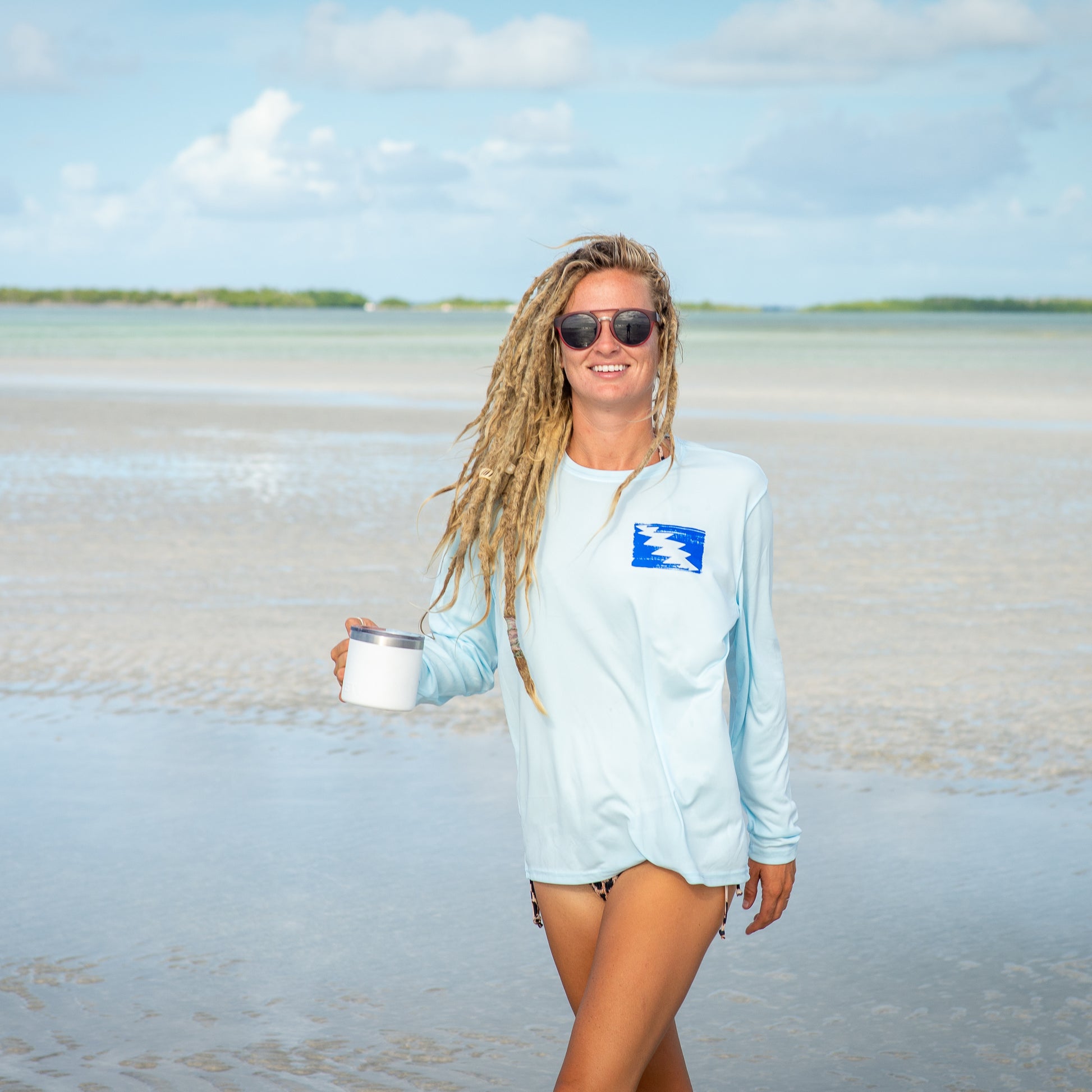 Grateful Diver Artist's Collection by Irina Pushkareva: Hawksbill Turtle UV Shirt in arctic blue front shot on model on sandbar