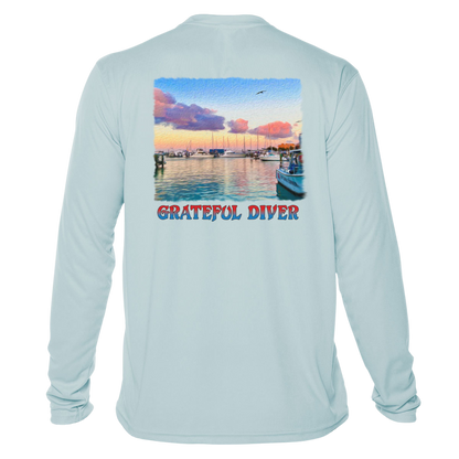 back of the Grateful Diver's Artist's Collection: Captain's Corner UV Shirt in arctic blue showing docked boats at sunrise