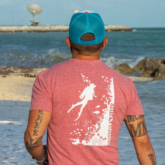 Grateful Diver Reef Diver T-shirt back in red on model in front of rocky coastline