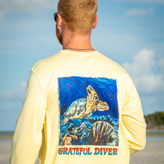 Grateful Diver Artist's Collection by Irina Pushkareva: Hawksbill Turtle UV Shirt in pale yellow back shot on model on sandbar