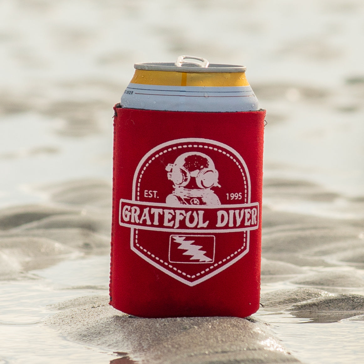 Grateful Diver Dive Can Koozie on sand