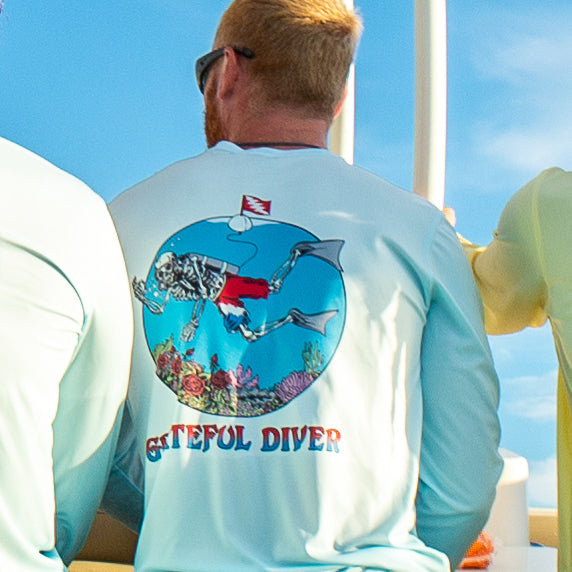 Grateful Diver Skeleton Diver UV Shirt on model showing the back design against a blue sky