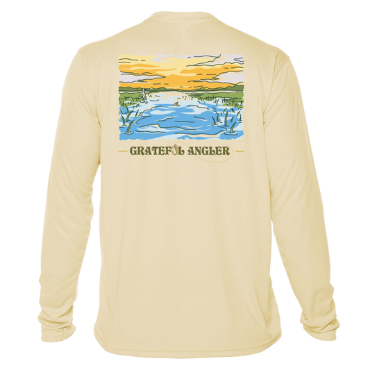 back of pale yellow Grateful Angler Tailing Redfish UV Shirt showing a redfish tail in a stream bed under sunny skies
